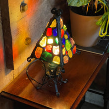 Load image into Gallery viewer, Colorful stained glass lamp on a wooden surface with a plant in the background