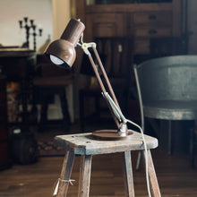Load image into Gallery viewer, Vintage-style desk lamp on a wooden stool in a dimly lit room.