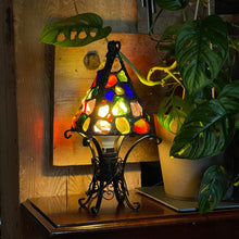 Load image into Gallery viewer, Stained glass lamp on a wooden surface with plants in the background